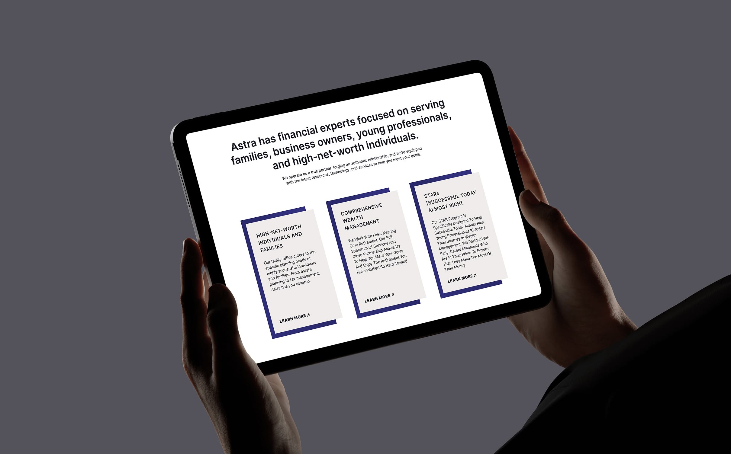 Astra-iPad-2 Hands holding a tablet displaying a section from the Astra Wealth Management website. Three columns of text detail services for high-net-worth individuals, wealth management, and stock options.