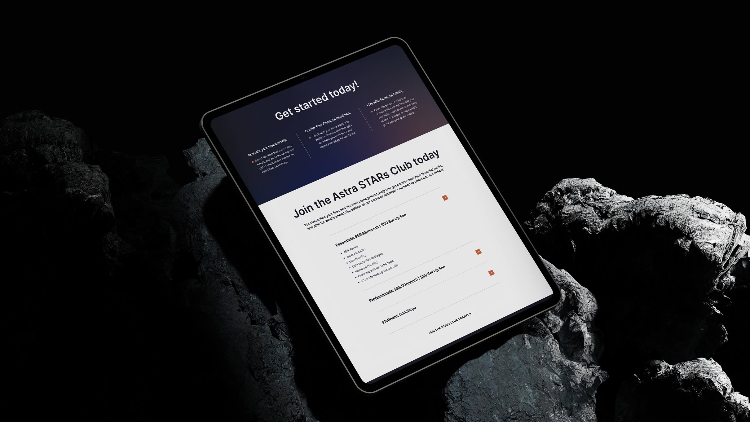 Astra-iPad-3 Tablet displaying a sign-up page titled "Join the Astra STARs Club today" rests on rugged, dark rocks.